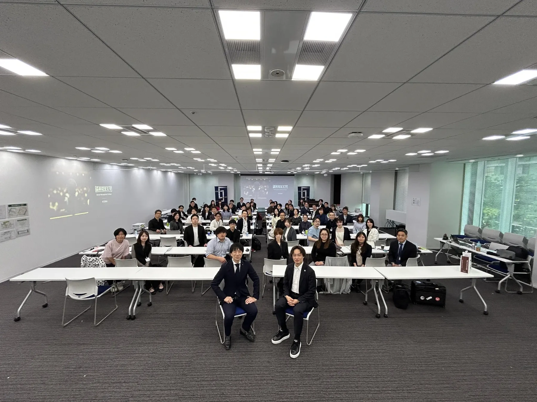 会議室で学ぶ歯科経営大学の受講生と講師の集合写真